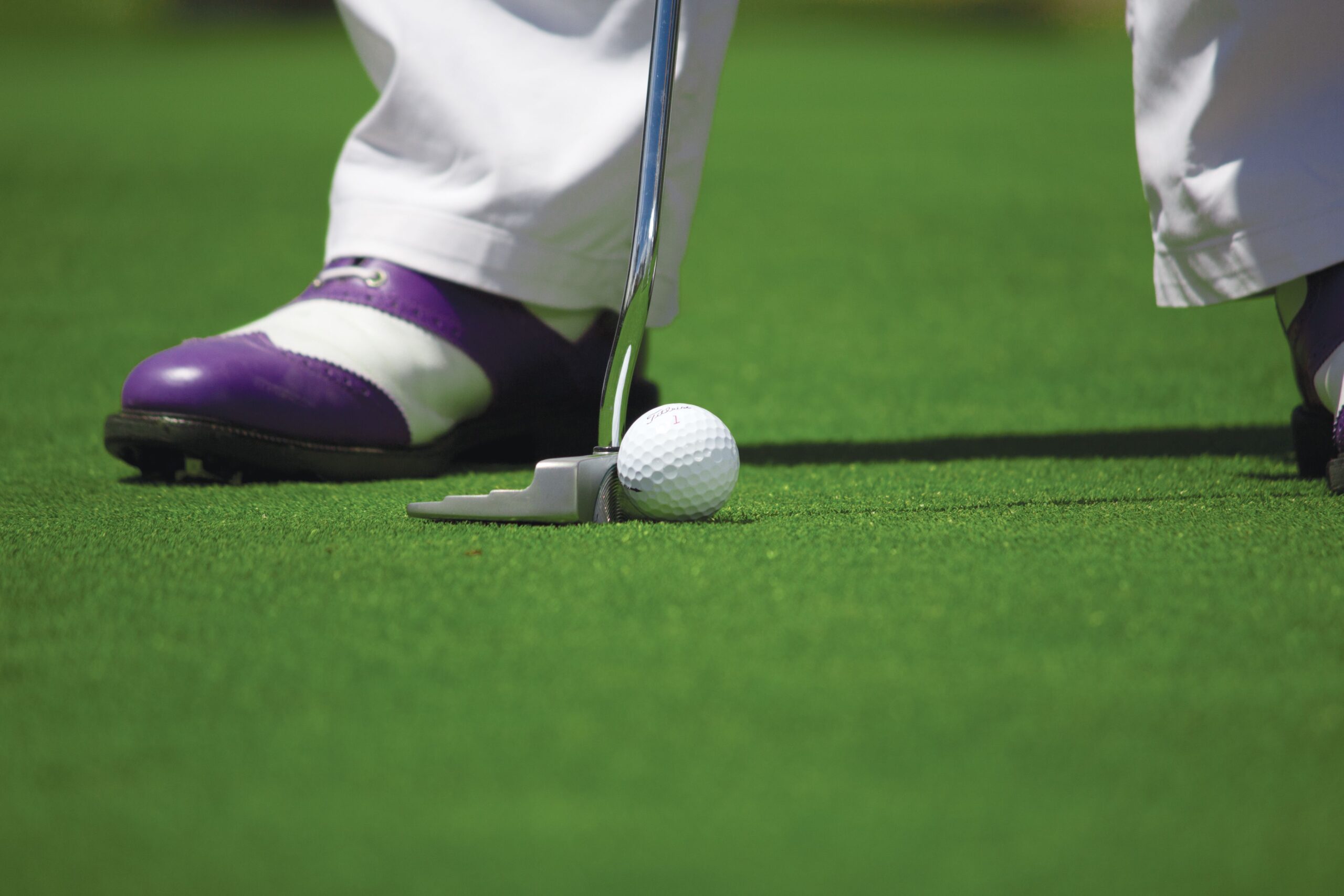 Golfer putting on green course